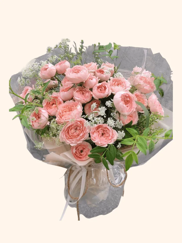 Full abundant apricot garden roses, white lace flower, fresh green foliage, and translucent ivory wrapping