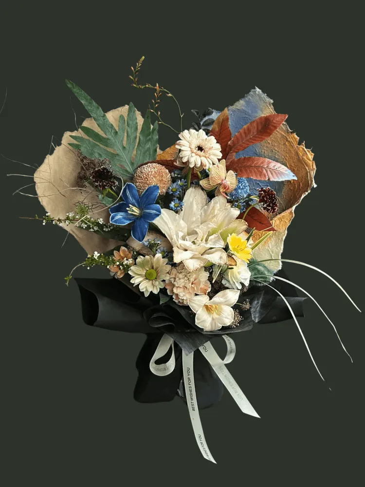 Full double cream lilies with a dyed blue tulip, champagne gerbera and carnations, orchids, rust chrysanthemums, and autumn foliage
