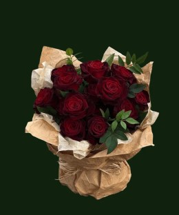 Deep burgundy roses with green foliage in natural kraft-style wrapping