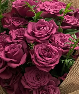 Close-up of layered mauve rose blooms and green foliage in the Blueberry bouquet.