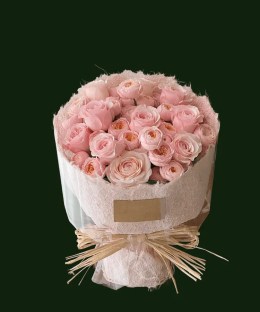 Pale blush roses in soft natural wrapping with a raffia tie