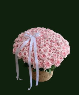 Large blush pink rose basket arrangement with fresh pink roses, greenery, and a flowing white ribbon.