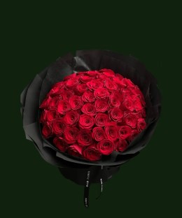 Large rounded bouquet of bright red roses in dramatic black wrapping