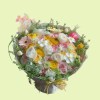 Full pink yellow and white ranunculus with garden roses, gerbera, tulip, lisianthus, craspedia, and lace flowers
