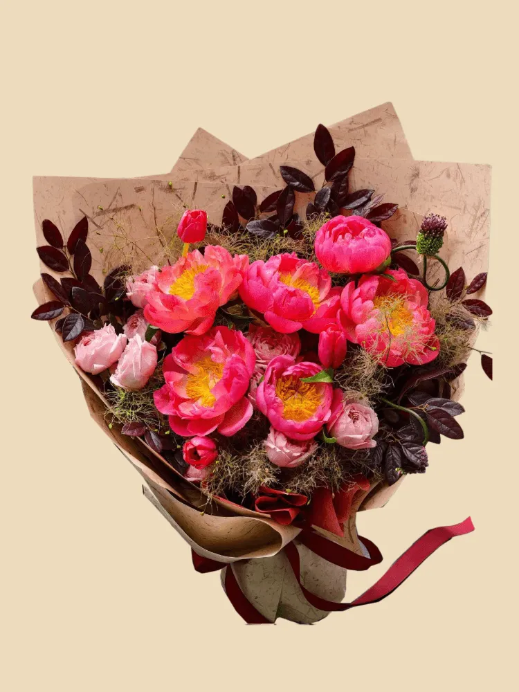 Full coral peonies, blush garden roses, red tulip buds, purple allium buds, and dark smoky foliage