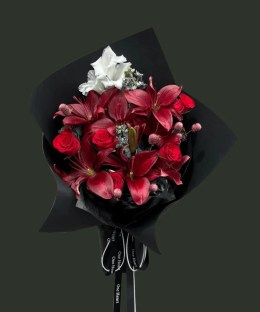 Full burgundy lilies and red roses with white gladiolus, silver dusty miller, pink round accents, and black wrapping