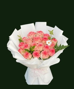 Peach-pink roses with greenery and white accents in sculptural white wrapping