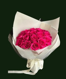 Fuchsia roses wrapped in white paper and cellphane with a flowing creamy ribbon.