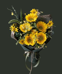 Full multiple sunflowers with yellow daisies, green foxtail grass, white Ammi, yellow oncidium, and dark forest wrapping