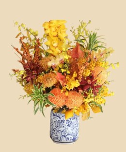 Full golden cymbidium orchids, orange pincushion protea, chrysanthemums, anthurium, berries, and gilded foliage in porcelain