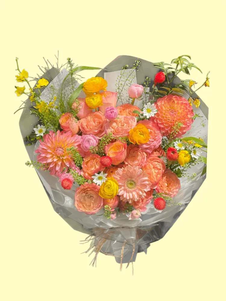Full peach dahlias, grapefruit garden roses, blush gerbera, yellow ranunculus, white daisies and red gomphrena