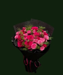 Hot pink roses and fresh foliage wrapped in layered black paper with a pink ribbon
