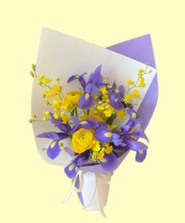 Full deep-purple irises, bright-yellow ranunculus and yellow oncidium in lavender and white wrapping