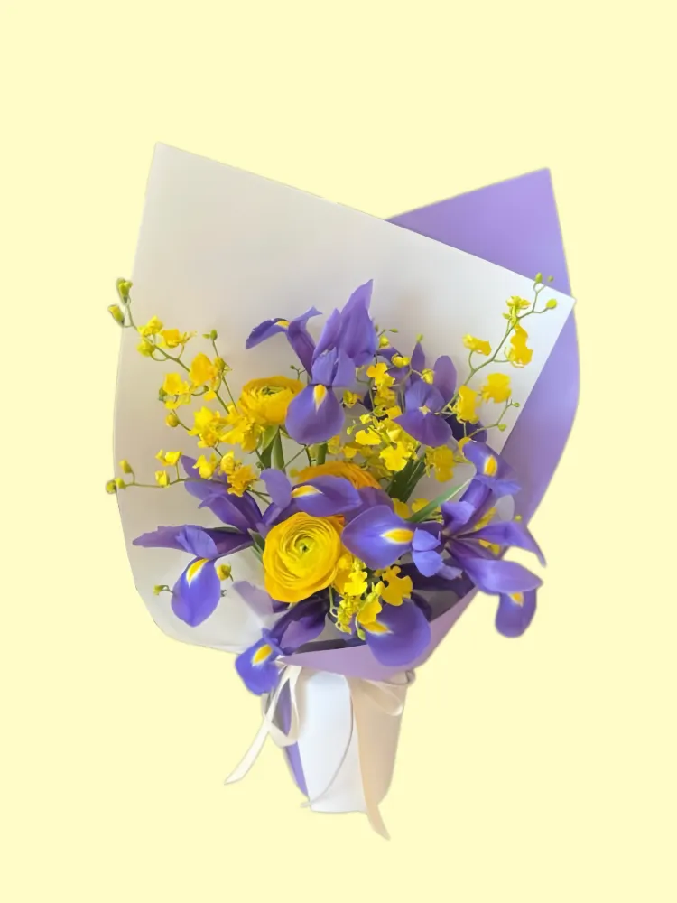 Full deep-purple irises, bright-yellow ranunculus and yellow oncidium in lavender and white wrapping