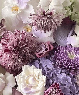 Close-up of lavender phalaenopsis orchids, striped dahlias, hydrangea, garden roses, chrysanthemums, and dark purple accents