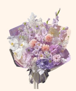 Full peach dahlias, lavender gladiolus, hydrangea, white phalaenopsis, pale anthurium, and purple scabiosa