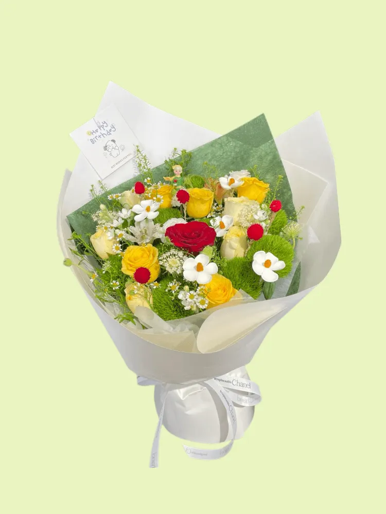 Full red yellow and cream roses, Green Trick dianthus, white ranunculus, meadow flowers, and a Little Prince figure