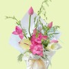 Full pink lotus blooms and buds with pale anthurium, white lily, lilac scabiosa, and flowing grasses