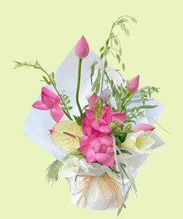 Full pink lotus blooms and buds with pale anthurium, white lily, lilac scabiosa, and flowing grasses