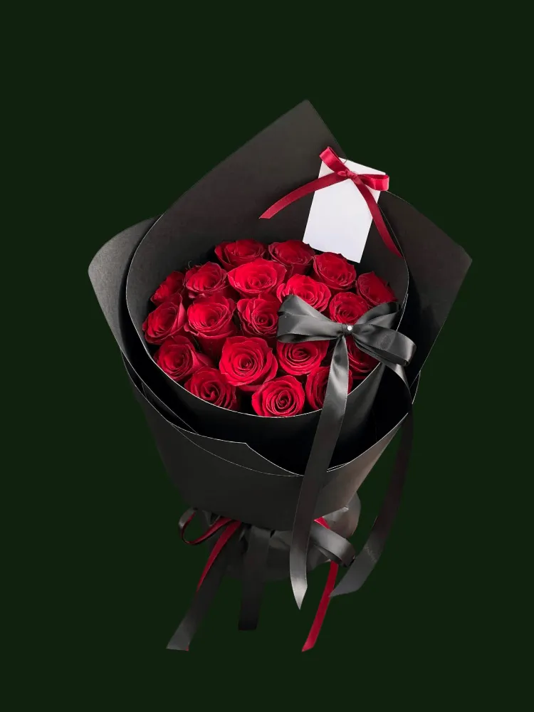 Fresh red roses in structured black wrapping with a wide black satin bow