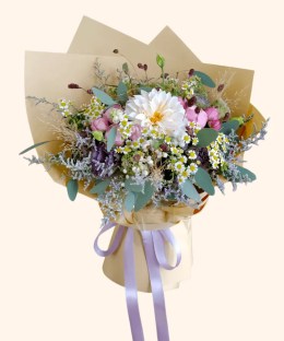 Full peach dahlia, chamomile, pink spray roses, purple lisianthus, eucalyptus, and dried meadow textures