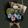 Full dyed blue roses with green anthurium, mauve gerbera, striped tulip, blue delphinium, thistles, daisies, and red gomphrena