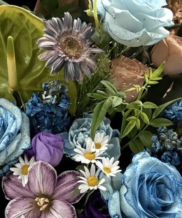 Close-up detail of dyed blue roses with green anthurium, mauve gerbera, striped tulip, blue delphinium, thistles, daisies, and red gomphrena