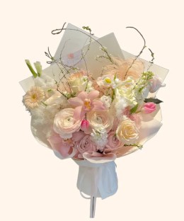 Full blush ranunculus, pink orchids, cream roses, white line flowers, gerbera, tulip, and feathers
