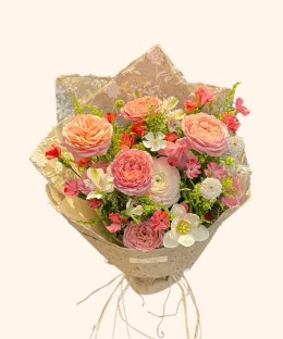 Full peach garden roses, white ranunculus, white tulip, alstroemeria, pink flowers, and green filler
