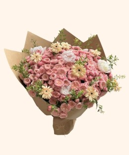 Full peach spray roses, cream peonies, pale-yellow gerbera, green foliage, and natural brown wrapping