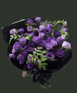 Full deep and pale purple lisianthus with slender green foliage in minimalist black wrapping