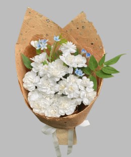 White garden roses and spray roses with blue tweedia in natural brown wrapping