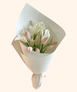 Full blush-pink tulips, white calla lilies, natural green leaves, and pale mint wrapping