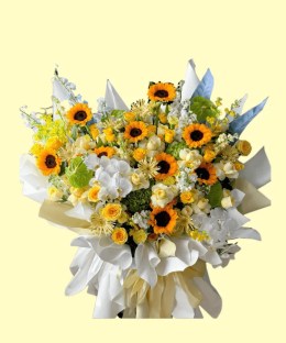 Full sunflowers, white phalaenopsis orchids, cream calla lilies, yellow and ivory roses, green hydrangea and blue accents