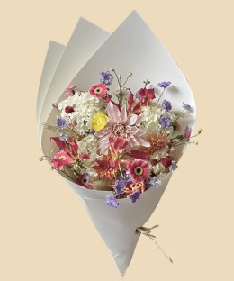Full blush dahlias with red gloriosa, white hydrangea, pink gerbera, yellow ranunculus, and purple delphinium