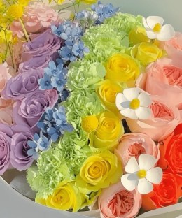 Close-up of pink, lavender, yellow, peach, and red roses in the Rainbow Reverie Rose Bouquet