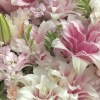 Close-up of double pink lilies, lavender stock, blush spray roses, green lily buds, and fresh foliage