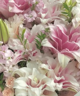 Close-up of double pink lilies, lavender stock, blush spray roses, green lily buds, and fresh foliage