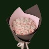 Soft blush pink roses arranged in layered pink and brown wrapping with a pale ribbon.