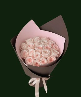 Soft blush pink roses arranged in layered pink and brown wrapping with a pale ribbon.