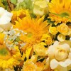Close-up detail of standard and Teddy Bear sunflowers with cream roses, oncidium orchids, snapdragons, green hydrangea, and white Ammi