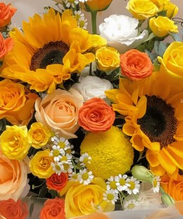 Close-up of sunflowers, champagne roses, and yellow roses in the Sunlit Meadow Sunflower Bouquet
