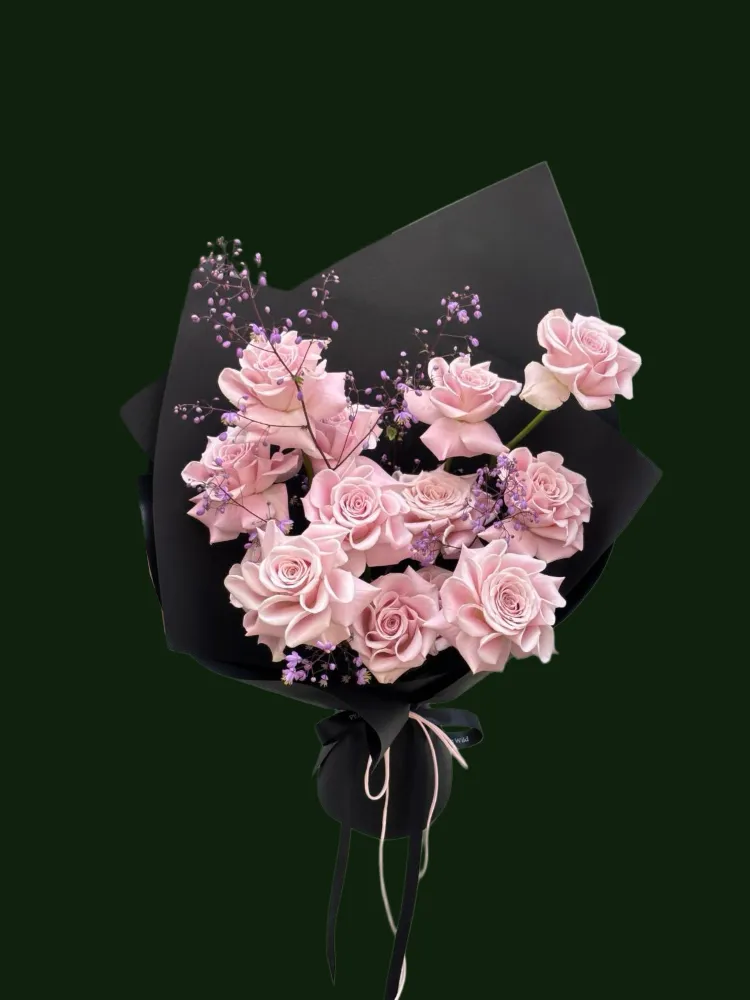 Pale pink roses with airy filler flowers in black and blush wrapping