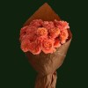 Soft tangerine roses arranged in warm brown paper wrapping