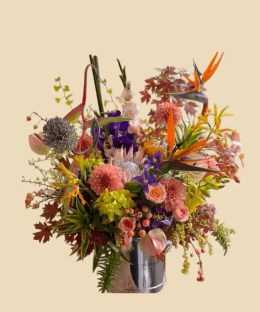 Full blush protea, bird of paradise, peach dahlias, orchids, anthurium, roses, berries, and autumn foliage