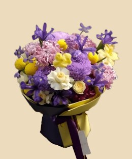 Full lilac chrysanthemums, violet iris, purple hydrangea, yellow orchids, creamy roses, and bright yellow accents