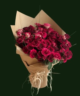 Violet-magenta roses with greenery in natural kraft-style wrapping
