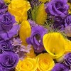 Close-up of deep-purple lisianthus and roses, yellow roses, tulips, calla lilies and oncidium in black wrapping