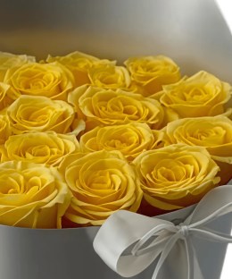 Close-up of fresh yellow rose heads in the silver hatbox arrangement.