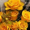 Close-up of golden roses and dark textural accents in the Lighthouse bouquet.